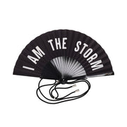 Schwarzer Fächer mit weißem Schriftzug „I AM THE STORM“ und Band am Griff