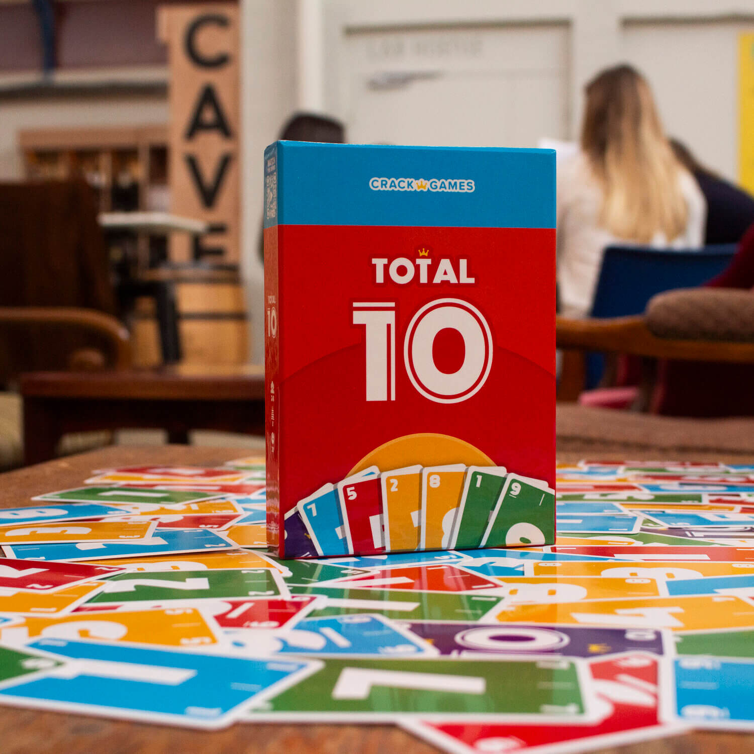 Spielbox Total 10 mit vielen Karten um den Tisch in einem Café