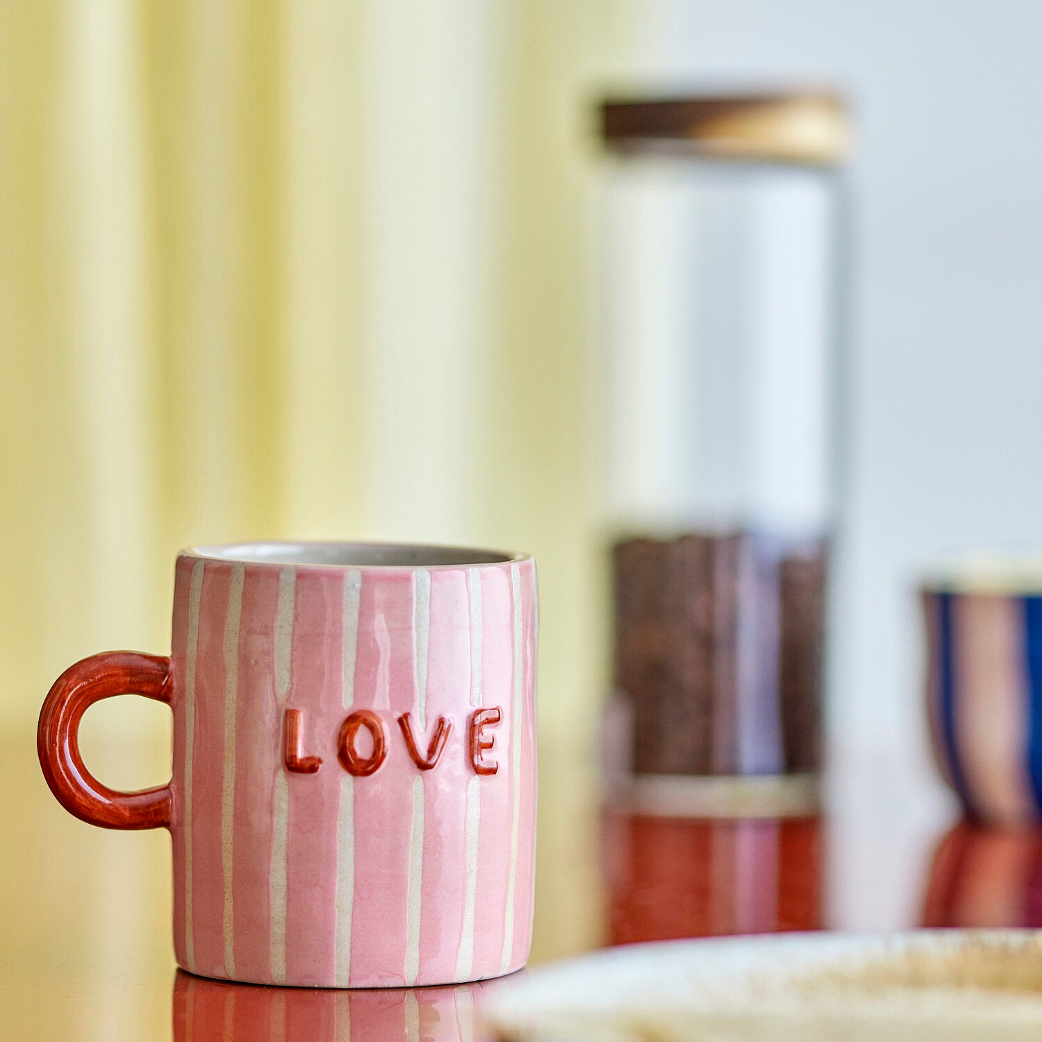 Rosa Keramikbecher mit weißen Streifen und Aufschrift „LOVE“, brauner Henkel