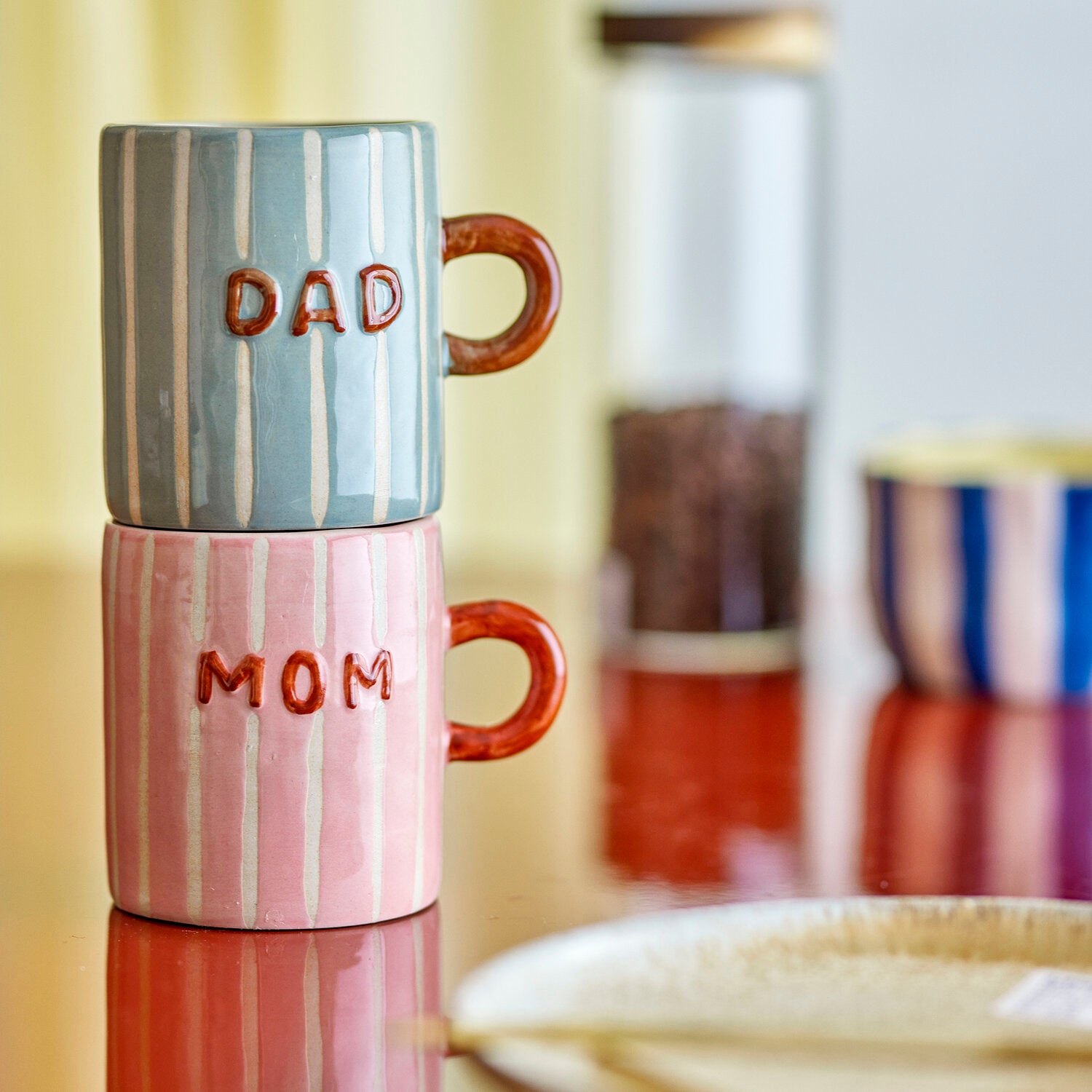 Gestapelte Keramikbecher: Rosa mit „MOM“ und „DAD“, je braunem Henkel