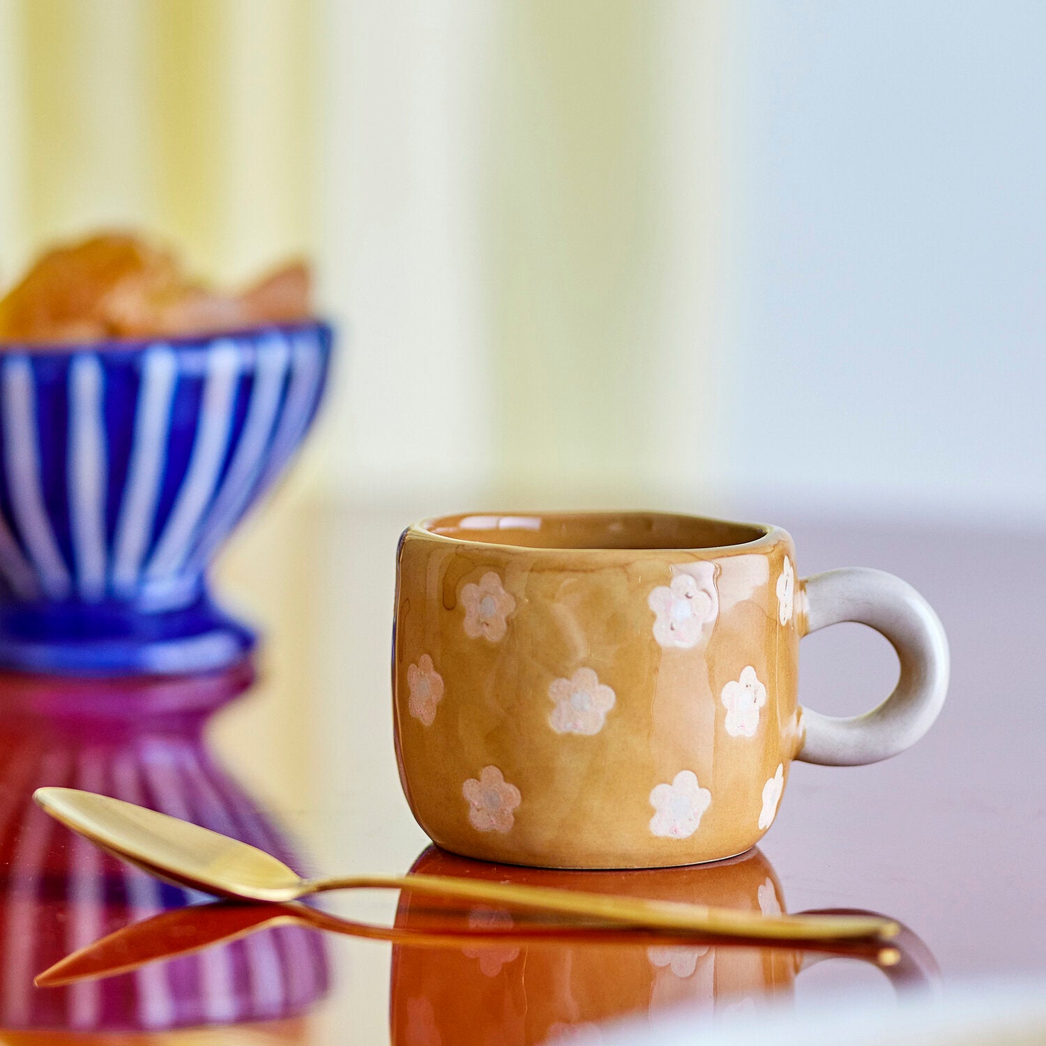 Braune Keramiktasse mit weißem Blumenmuster, glatte Glasur und seitlicher Griffmulde