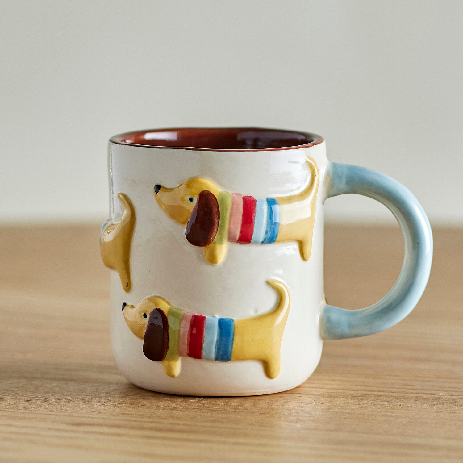 Bunte Hundemotiv-Tasse mit hellblauem Henkel und rotem Rand, keramisch, ca. 8×8 cm