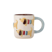 Bunte Keramiktasse mit Hundemotiv, beigen Korpus, hellblauer Henkel, innen dunkel