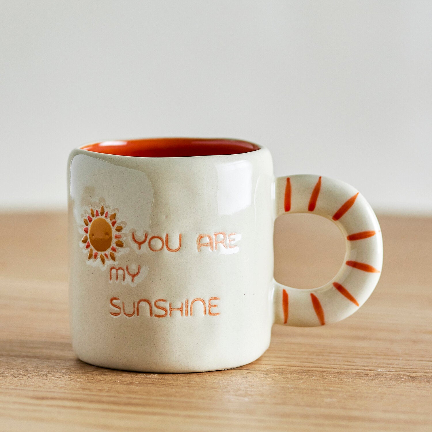 Weiße Tasse mit orangefarbenem Innenrand, „YOU ARE MY SUNSHINE“ und Sonnenmotiv