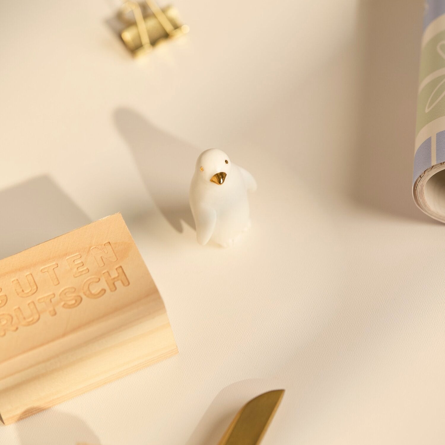 Pinguinfigur mit goldenem Maul auf Holz-Glückskästchen „Guten Rutsch“
