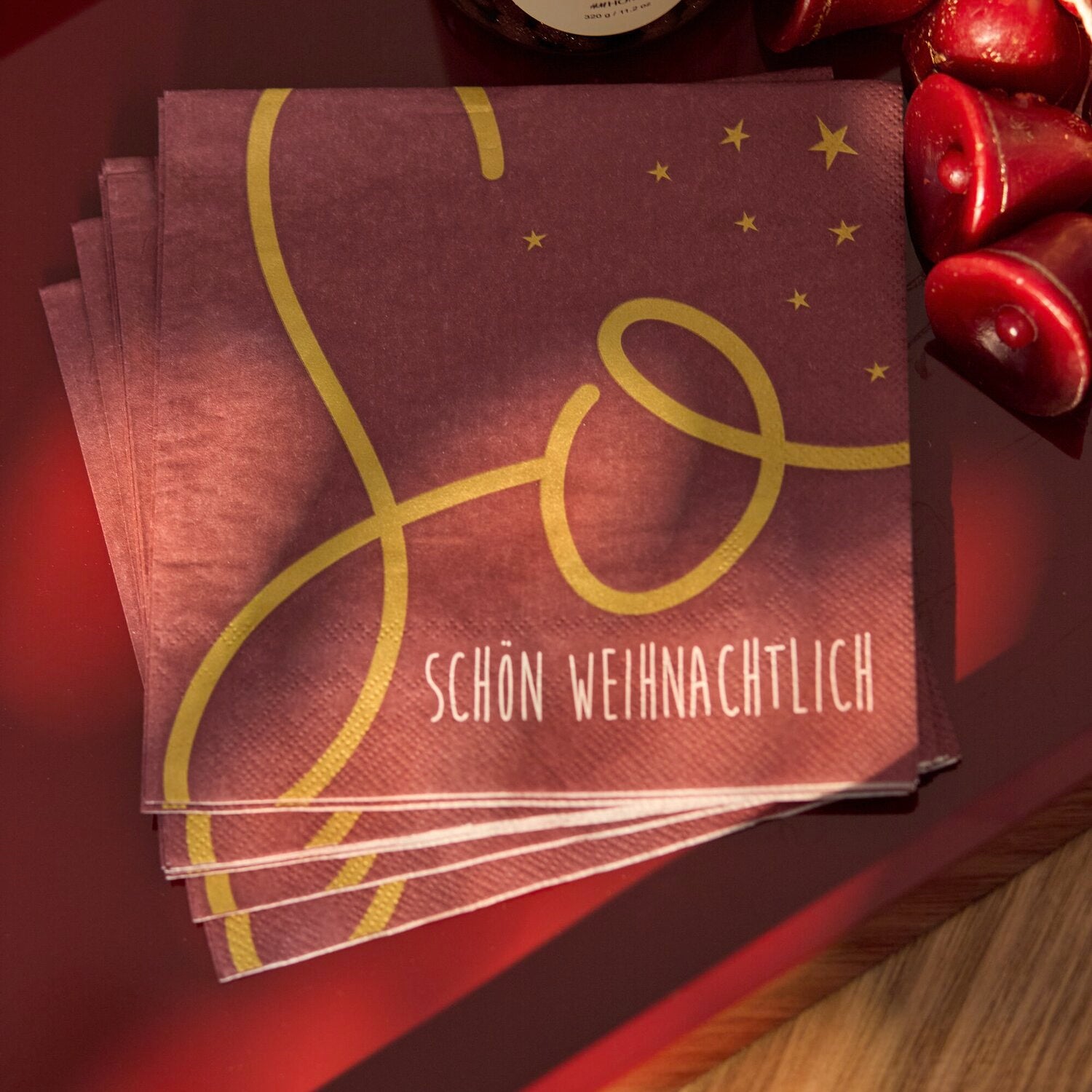 Paket burgunderfarbener Weihnachtsservietten mit goldenen Ornamenten, Sternen und „SCHÖN WEIHNACHTLICH“