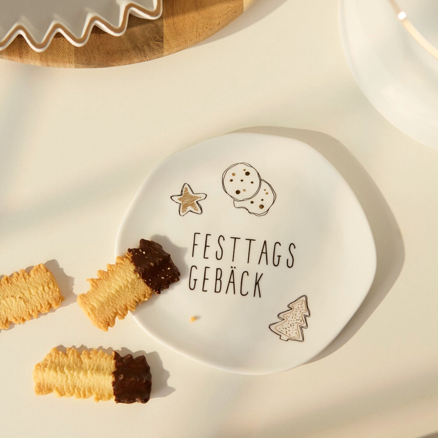 Kleiner weißer Teller mit „FESTTAGS GEBÄCK“, Stern- und Weihnachtsbaum-Illustrationen