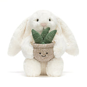 Kuscheltierhase in Creme mit grauem Pflanzentopf und grünen Blättern