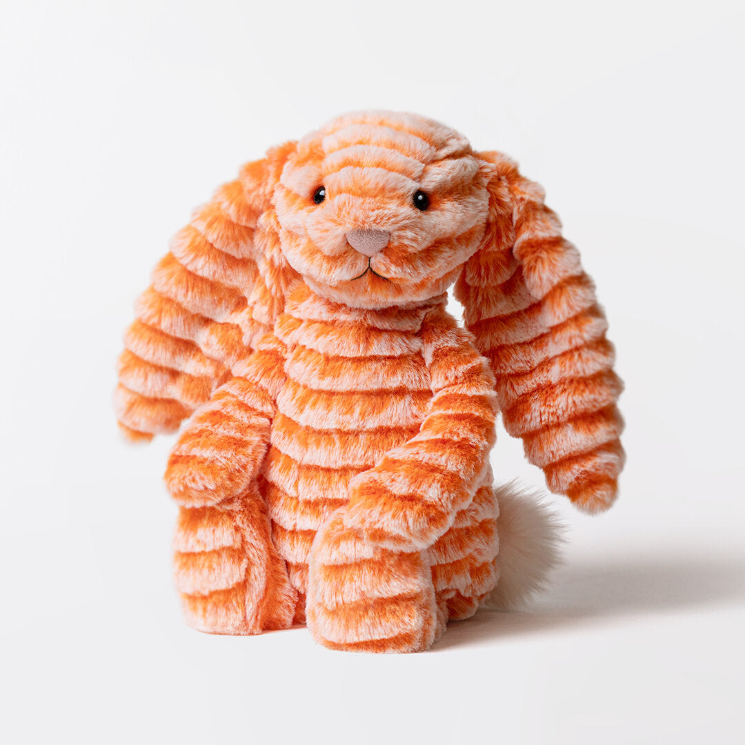 Kuscheltierhase aus orangefarbenem Plüsch, blickt nach vorn, stehende Haltung.