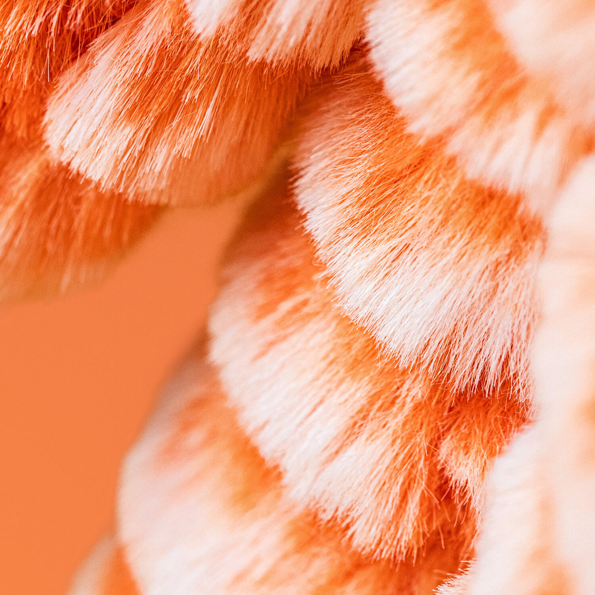 Nahaufnahme einer orangefarbenen Kuscheltierhasen-Pfote aus Plüsch.