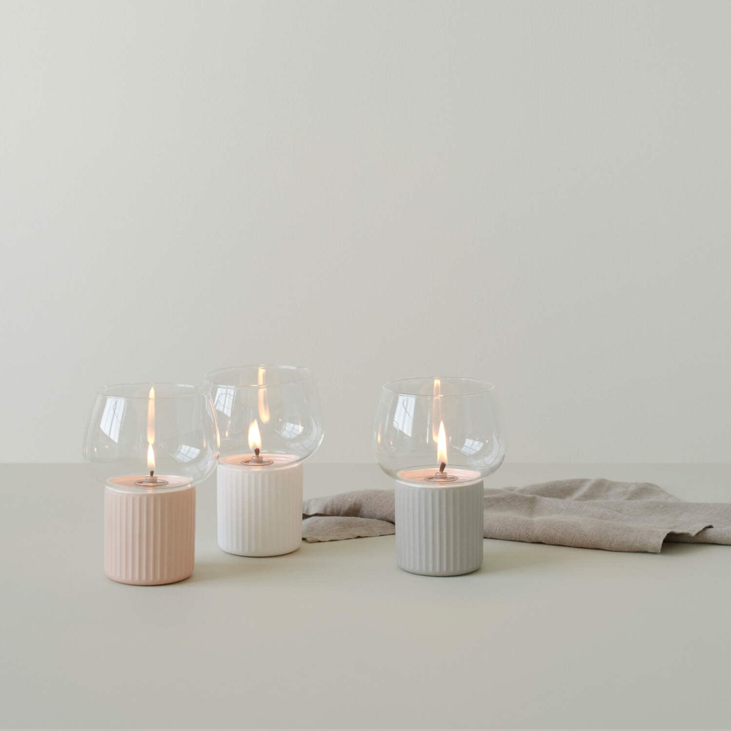 Windlicht HYGGE mit transparentem Glasaufsatz und geriffeltem rosa Sockel, aufgestellt