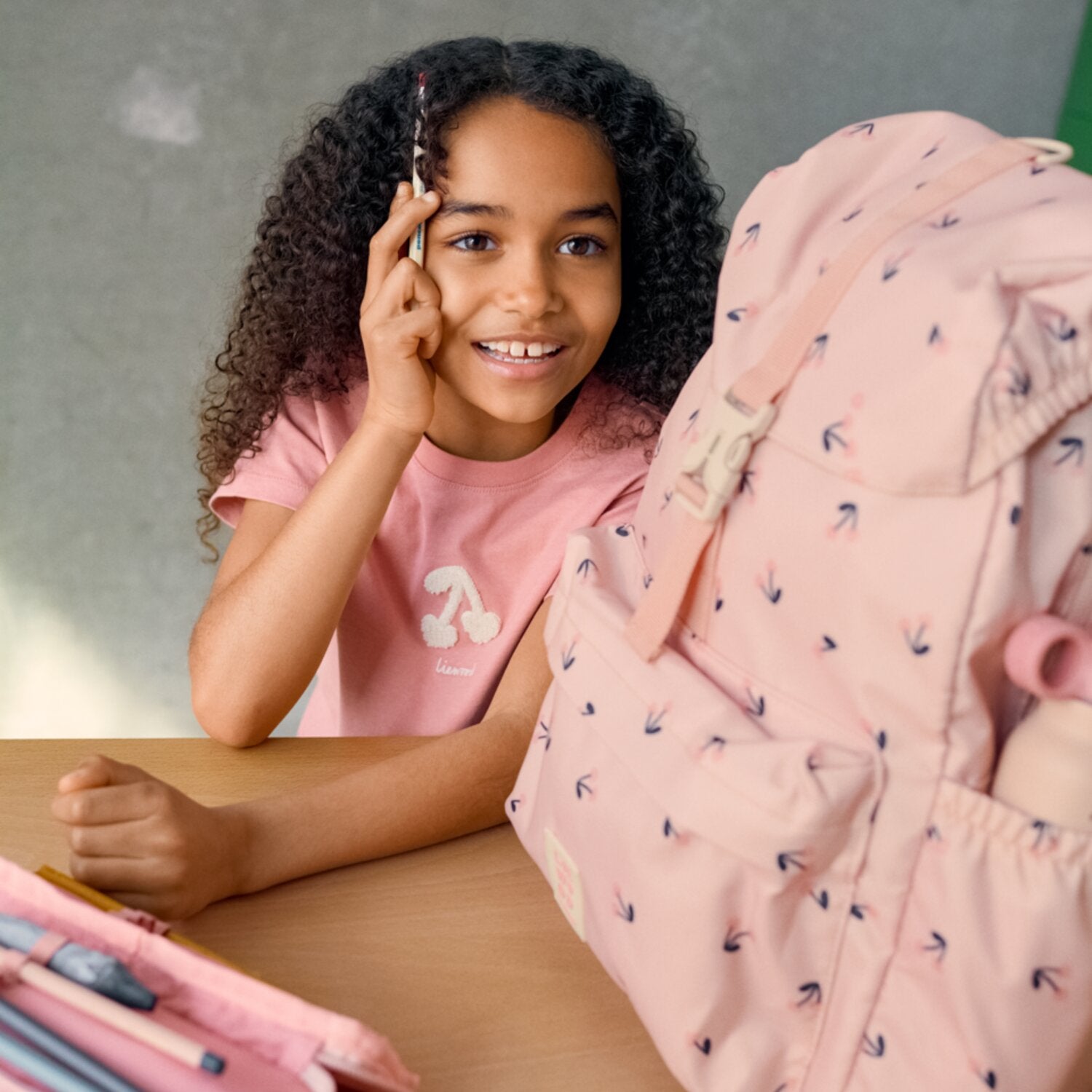 Rosa Schulrucksack mit Schulterriemen und Herzmuster, Reißverschluss sichtbar
