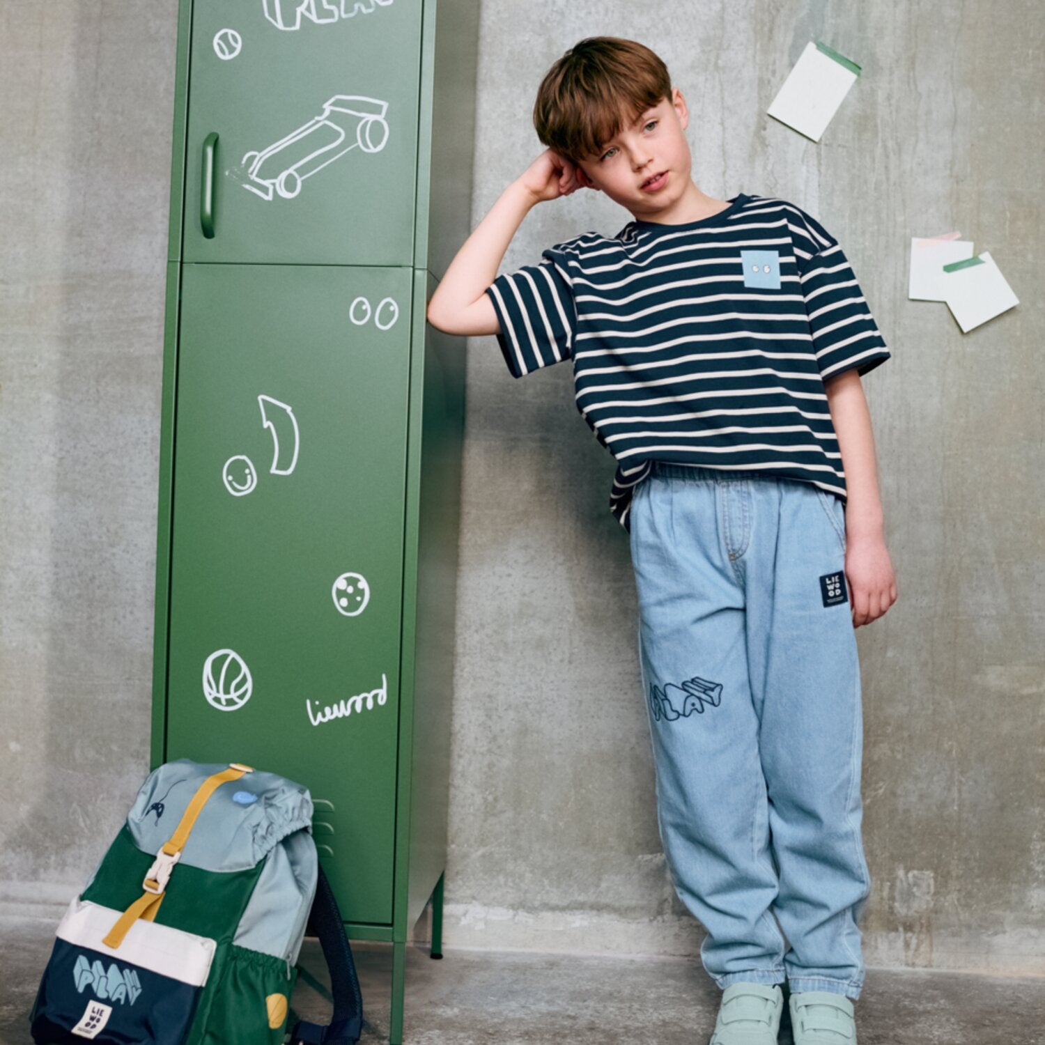 Schulrucksack am Kind getragen, dunkelblau mit Grafik und hellen Details