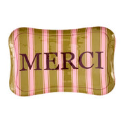 Metalltablett mit vertikalen Streifen in Rosa und Gelb, gerundete Ecken, Schriftzug „MERCI“.