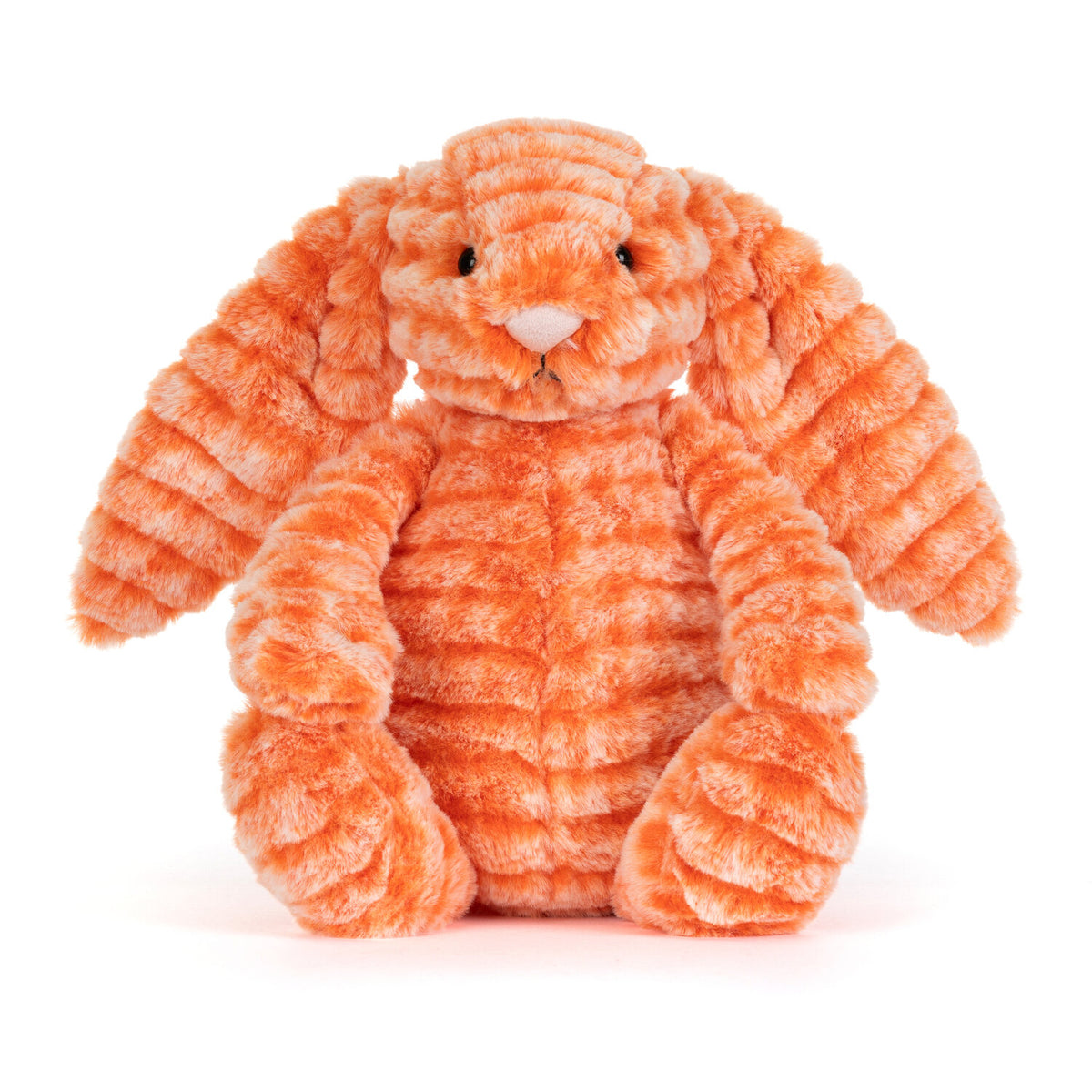 Kuscheltierhase aus orangefarbenem Plüsch, sitzt zusammengerollt.