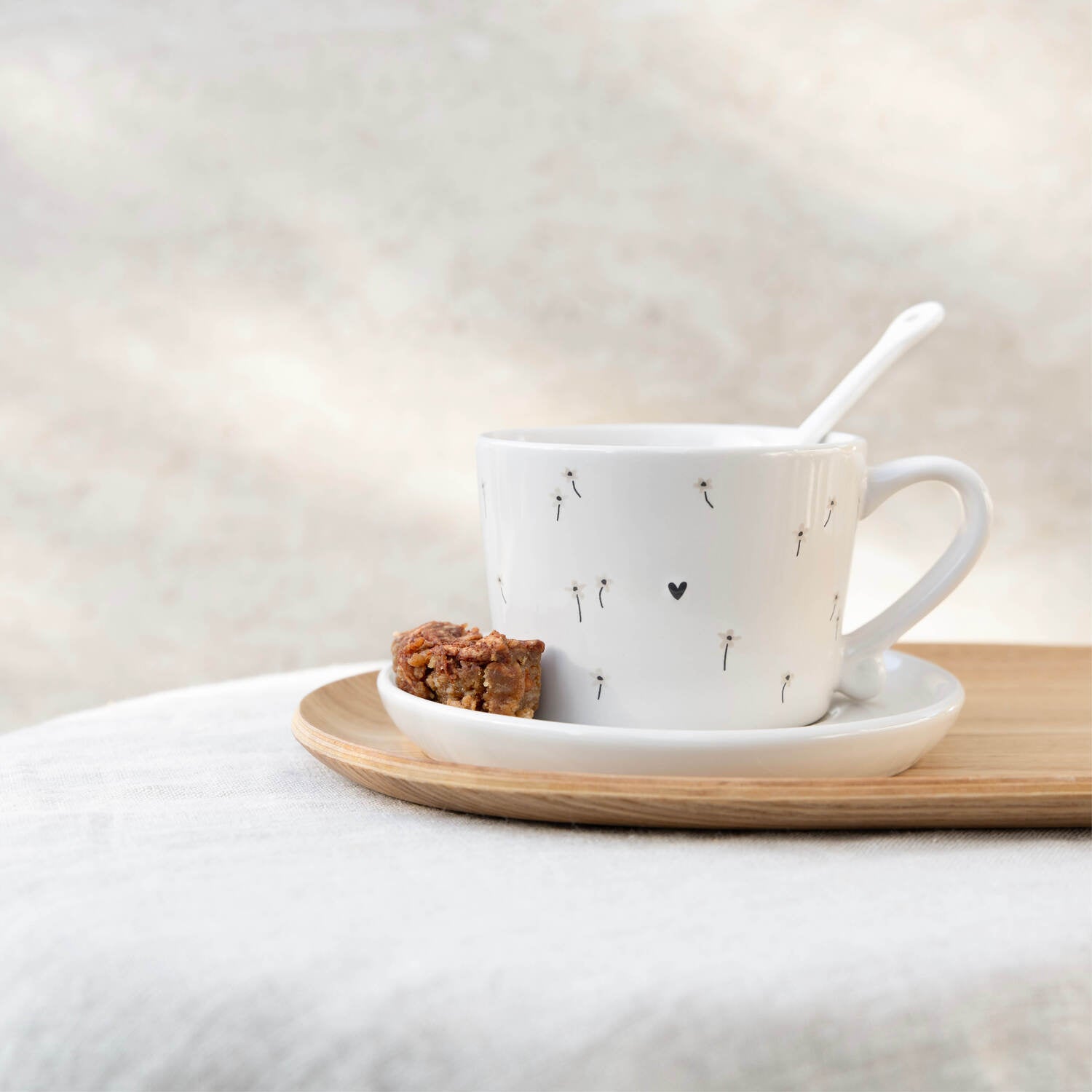 Weiße Keramiktasse mit Herzmotiv, Löffel und Untertasse