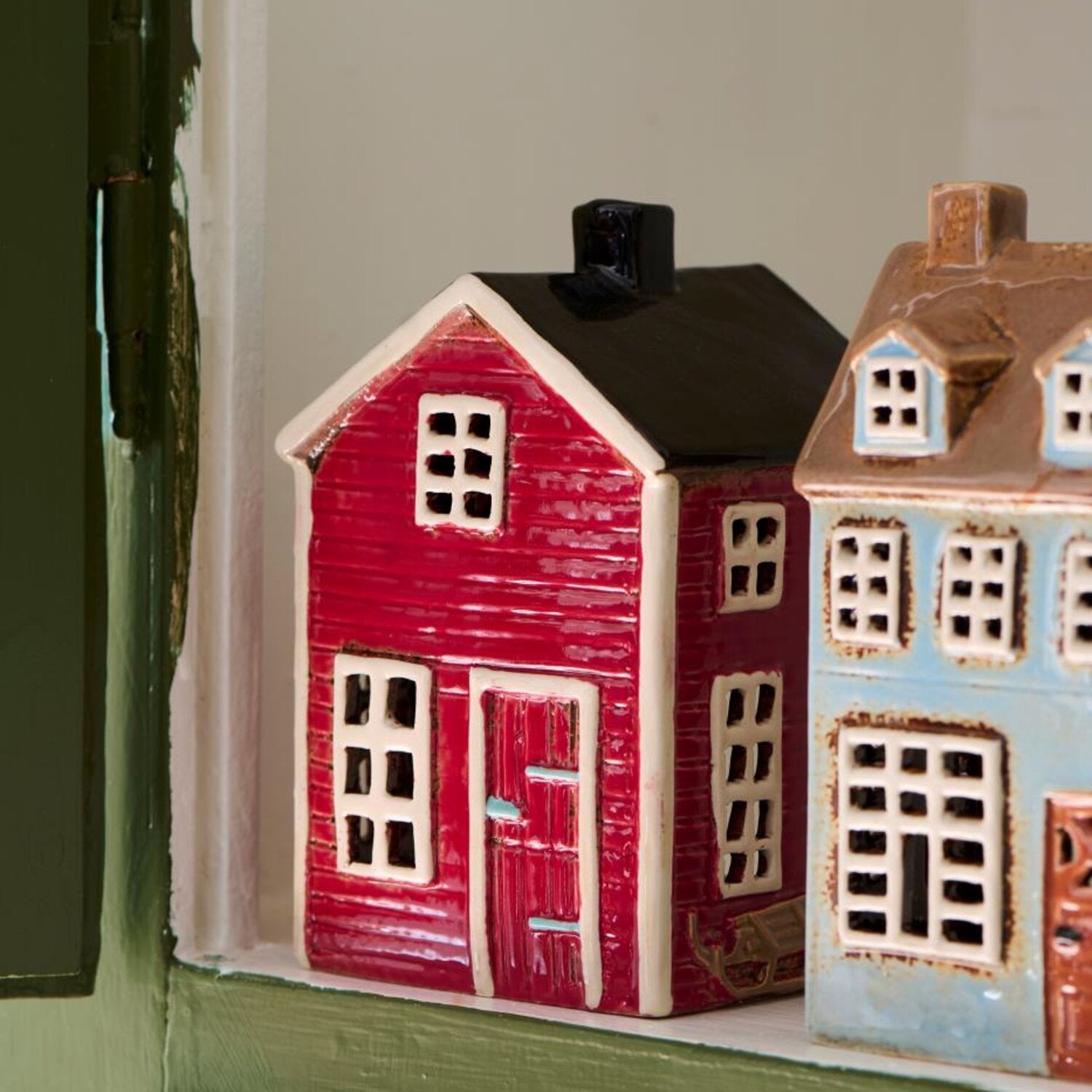 Rotes Teelicht-Haus mit schwarzem Schornstein, Fenster und Tür
