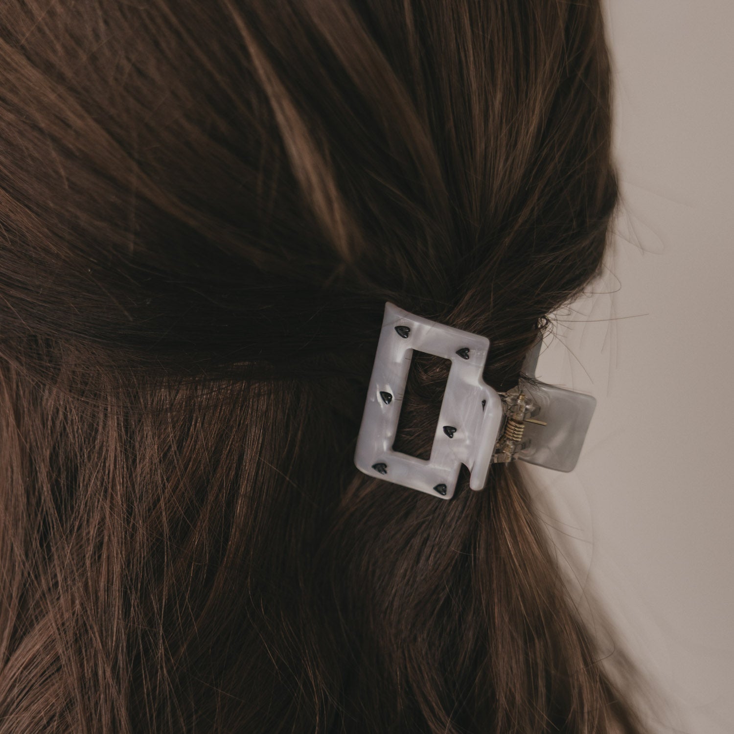Kleine eckige Haarspange mit schwarzen Herzmotiven auf hellem Metallclip