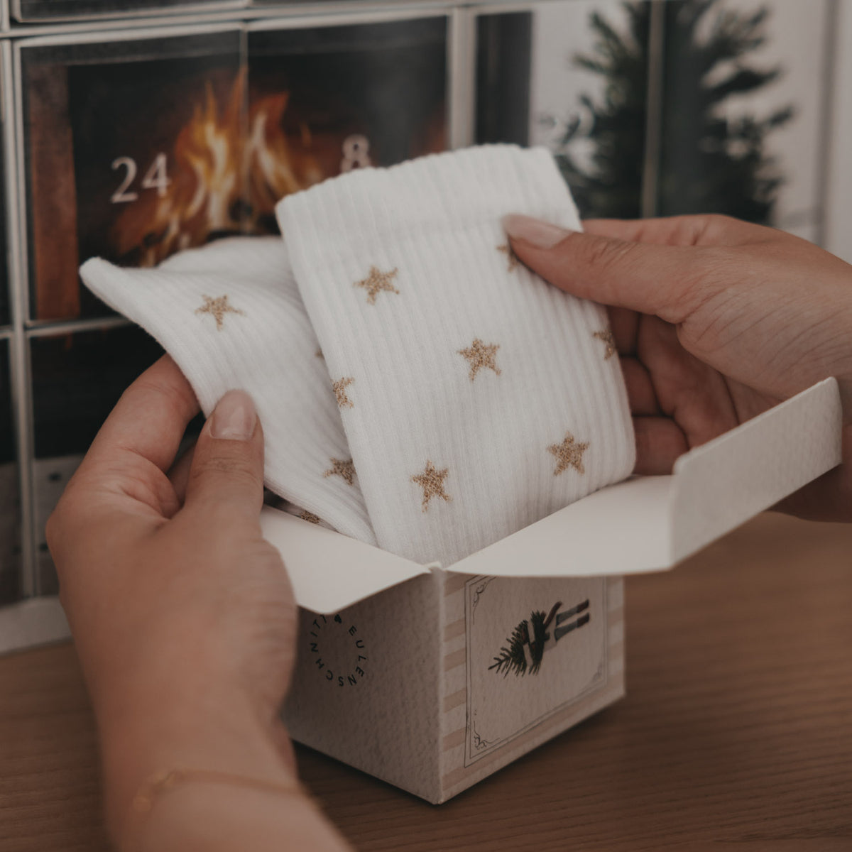 Socken-Adventskalender, geöffnete Schachtel mit weißen Socken mit goldenen Sternen