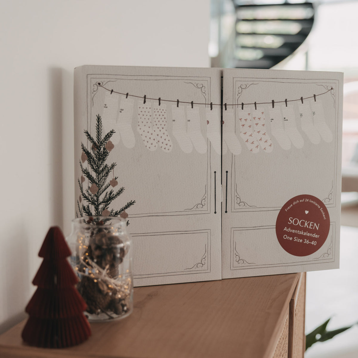Socken-Adventskalender, geöffnete Klappbox mit Socken-Illustrationen und rotem Siegel
