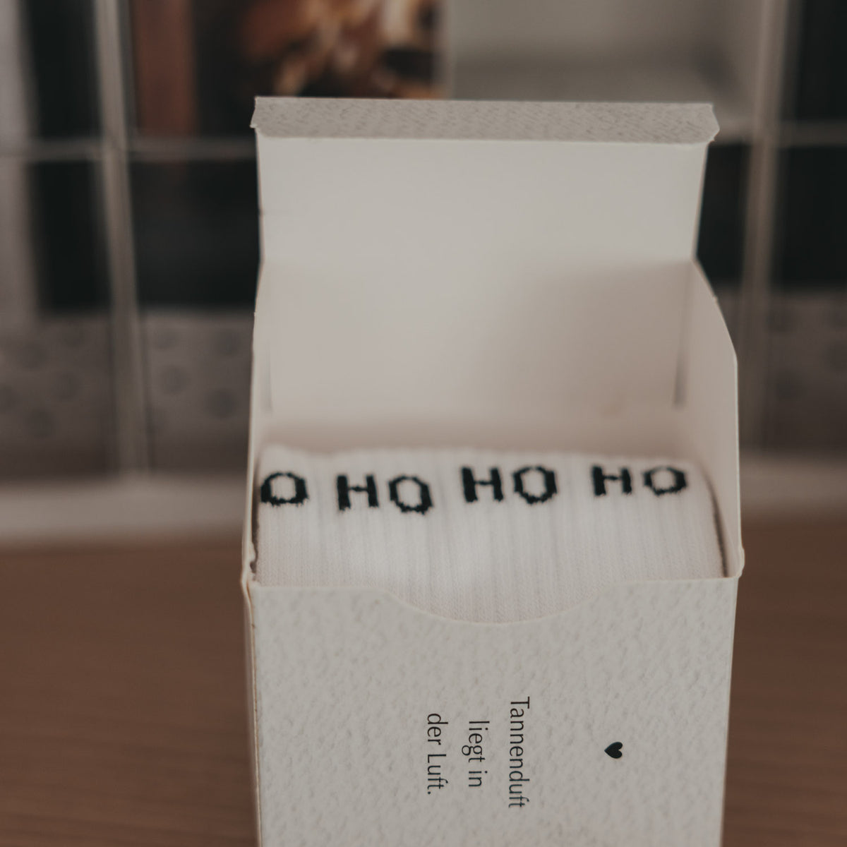 Socken-Adventskalender, offene weiße Schachtel mit „Ho Ho Ho“ Aufdruck