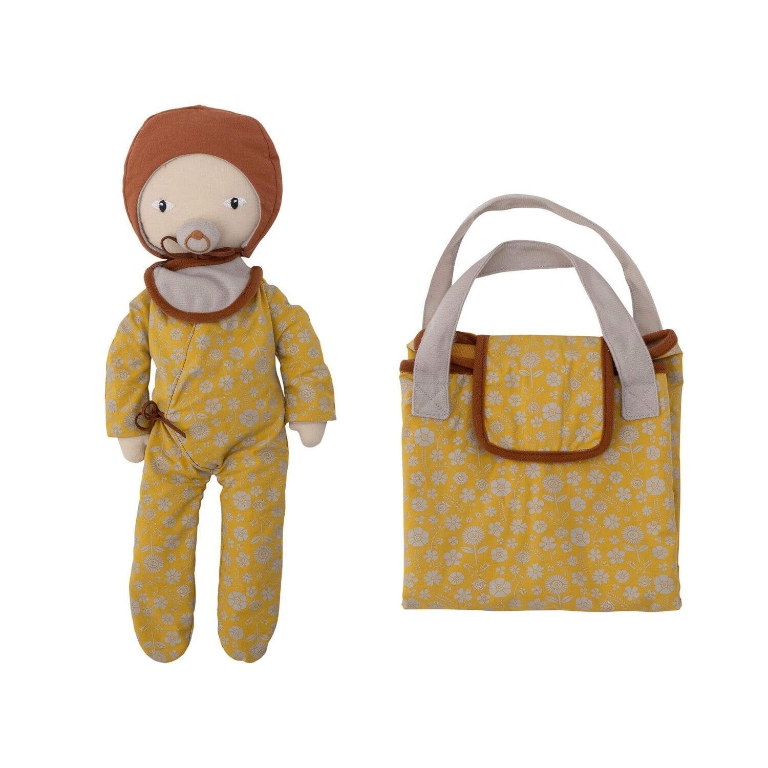 Stoffpuppe mit gelbem Blumen-Outfit, brauner Mütze und Tragetasche