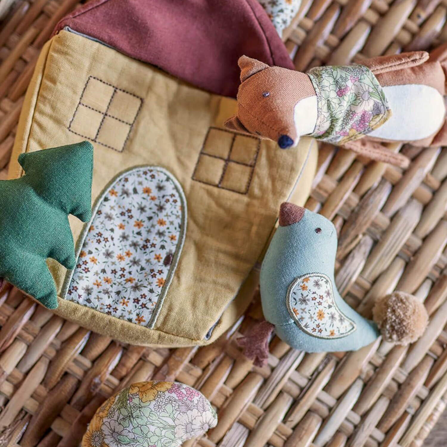 Stoff-Spielzeug: Stoffhaus mit Flicken und zwei kleinen Tierfiguren am Korb