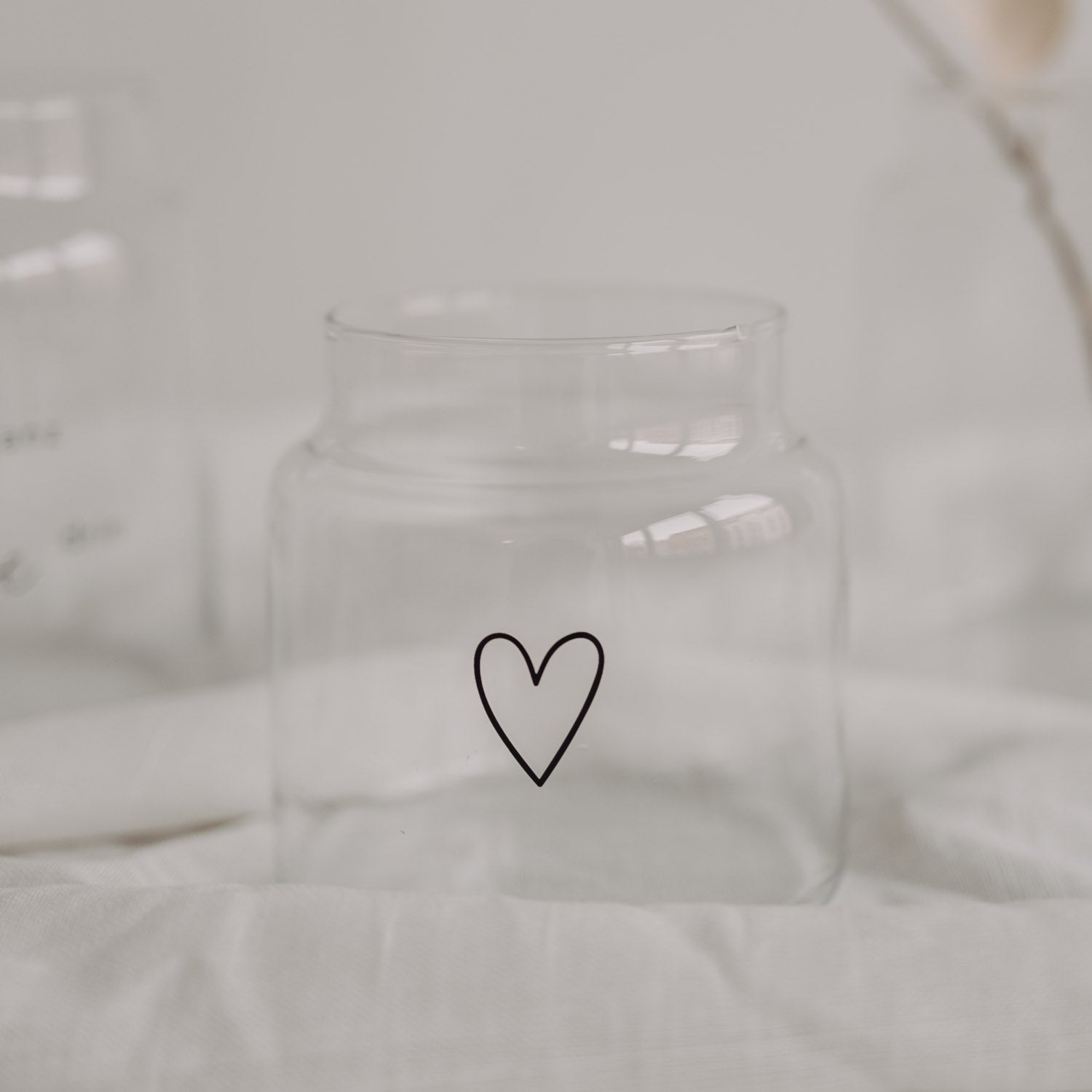 Transparente Glasvase mit Herz-Symbol, frontal im Nahblick
