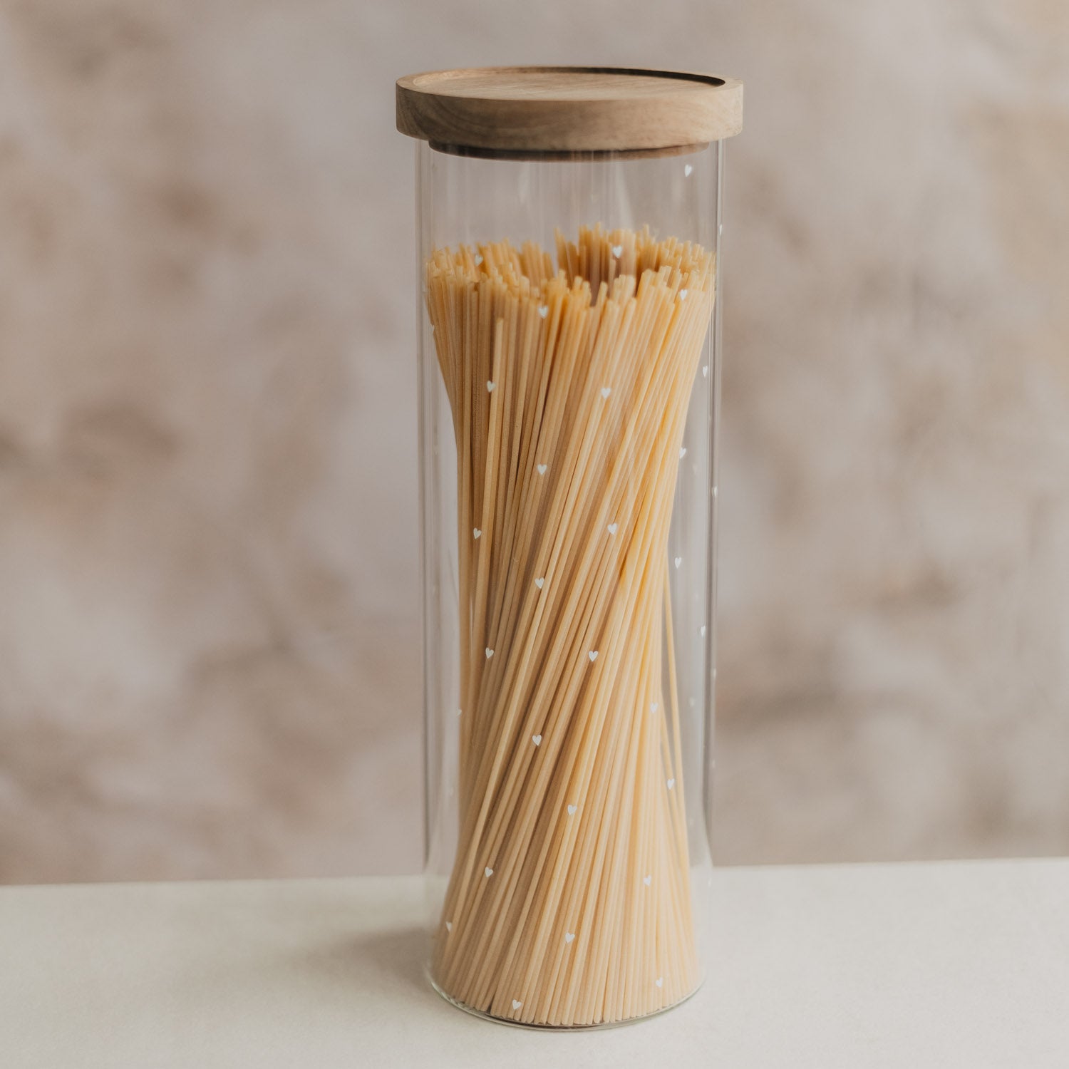 Vorratsglas aus transparentem Glas mit Holzdeckel, gefüllt mit langen Stäbchen