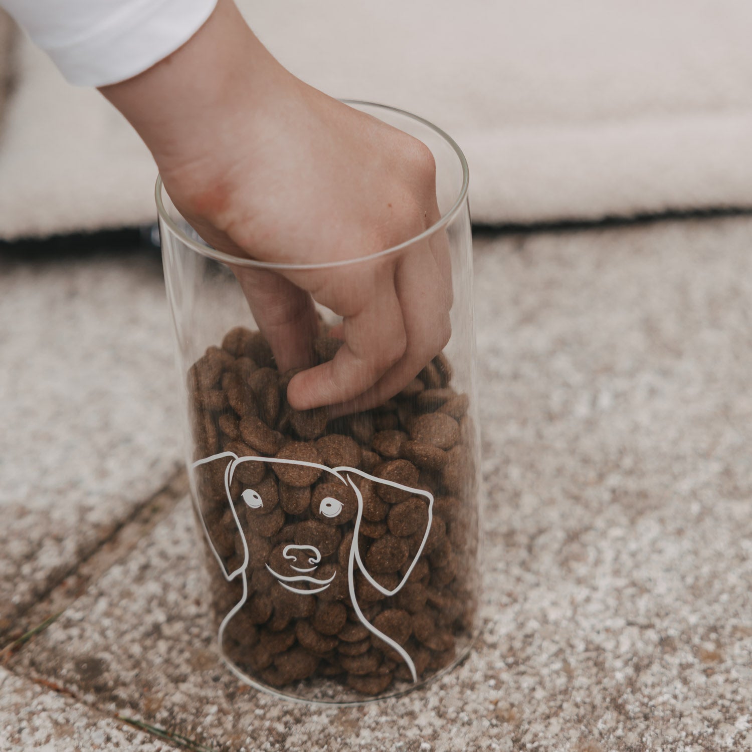 Vorratsglas aus Klarglas mit Holzdeckel und Hund-Motiv, gefüllt mit braunen Kroketten