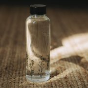 Transparente Trinkflasche 500 ml mit schwarzem Deckel und Blumenwiesen-Motiv