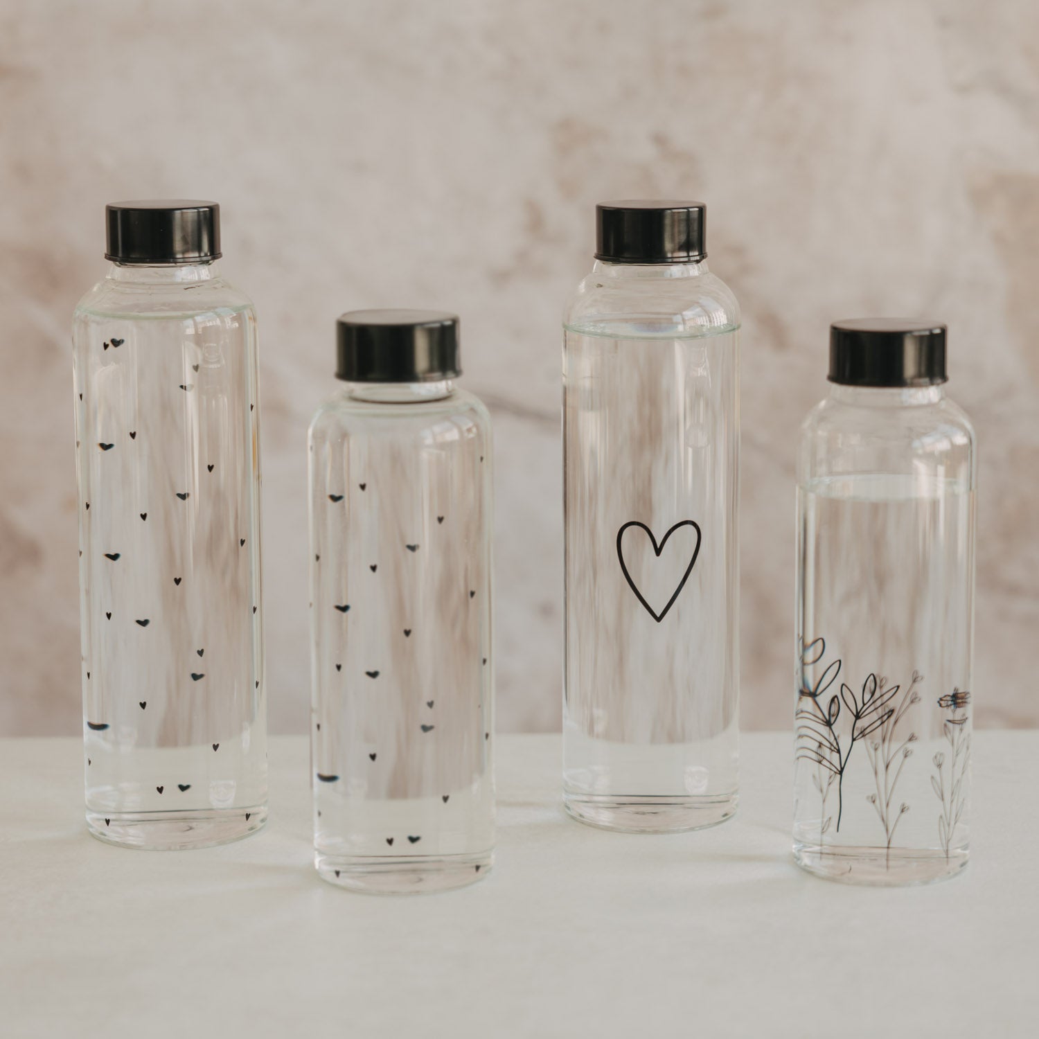 Set transparenter Trinkflaschen mit schwarzen Deckeln und unterschiedlichen Motiven, je 500 ml