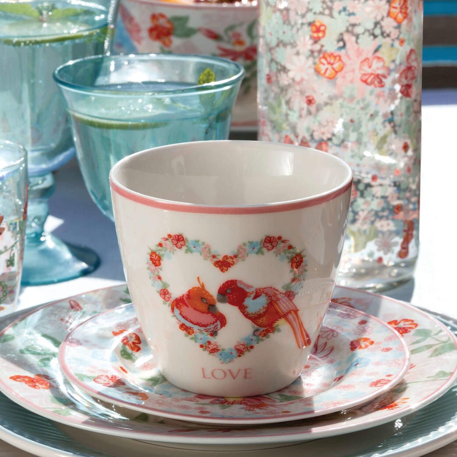 Porzellan-Tasse mit Vögel- und Blumenmotiv sowie „LOVE“-Schriftzug, auf Unterteller