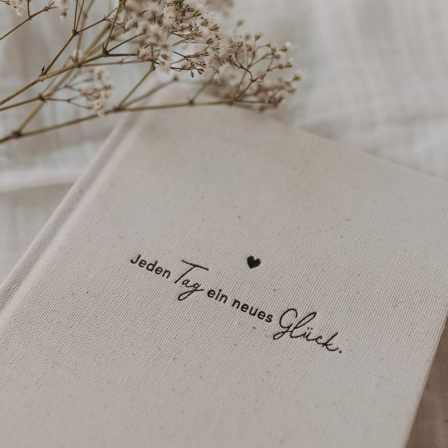 Terminkalender mit Naturleinen-Cover und Schriftzug „Jeden Tag ein neues Glück“