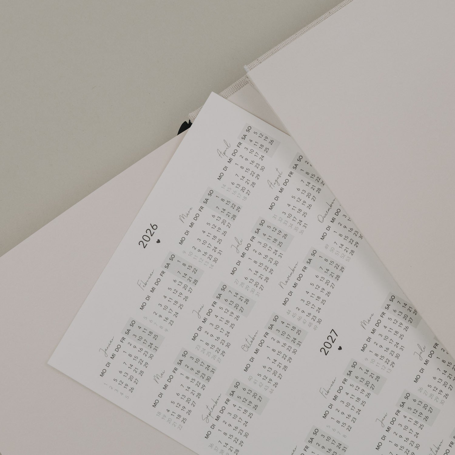 Terminkalender: Monatskalender mit Datumsraster und Jahreszahlen 2026/2027 auf Papier