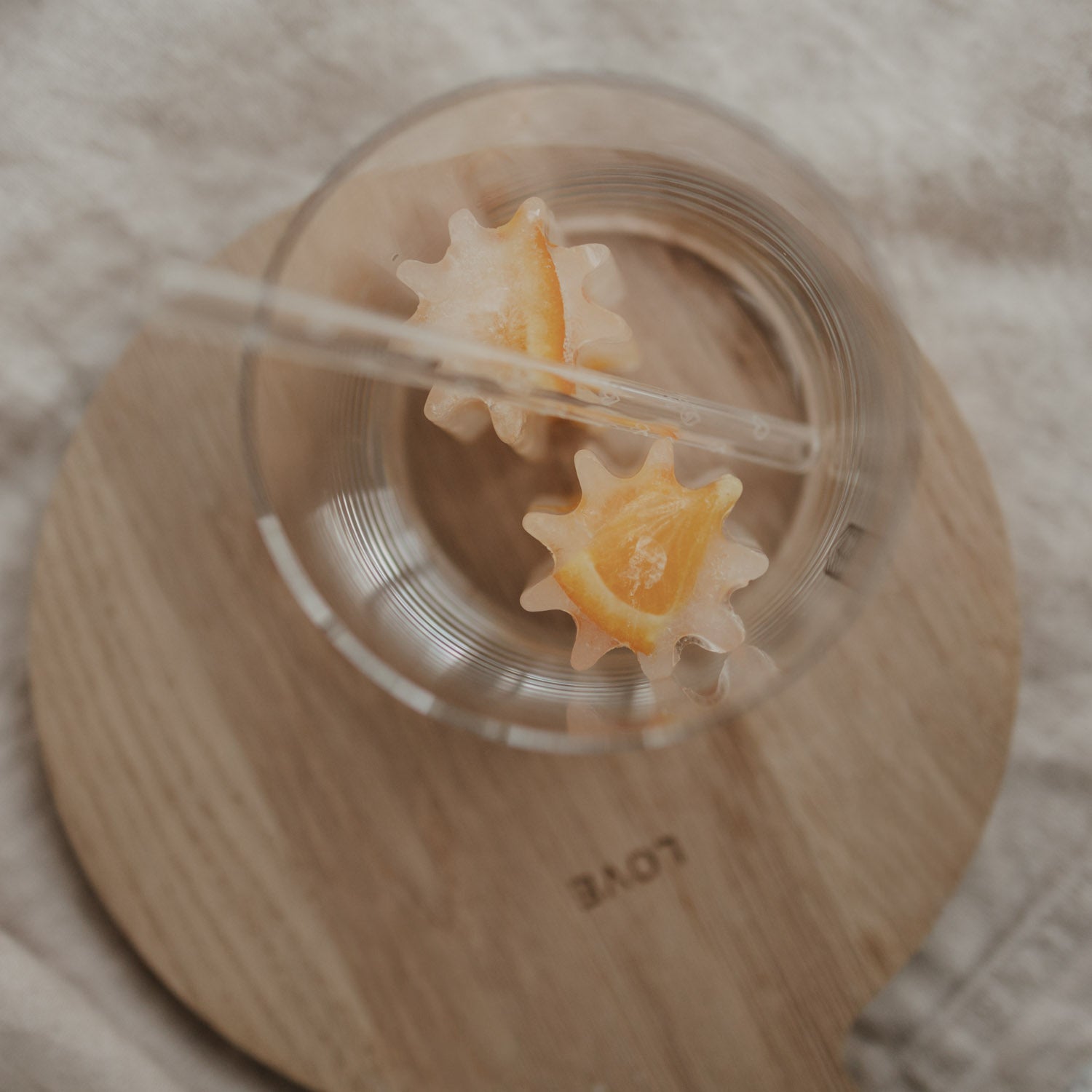Blumenförmiger Eiswürfel in Klarsichtdose, orangefarbener Inhalt