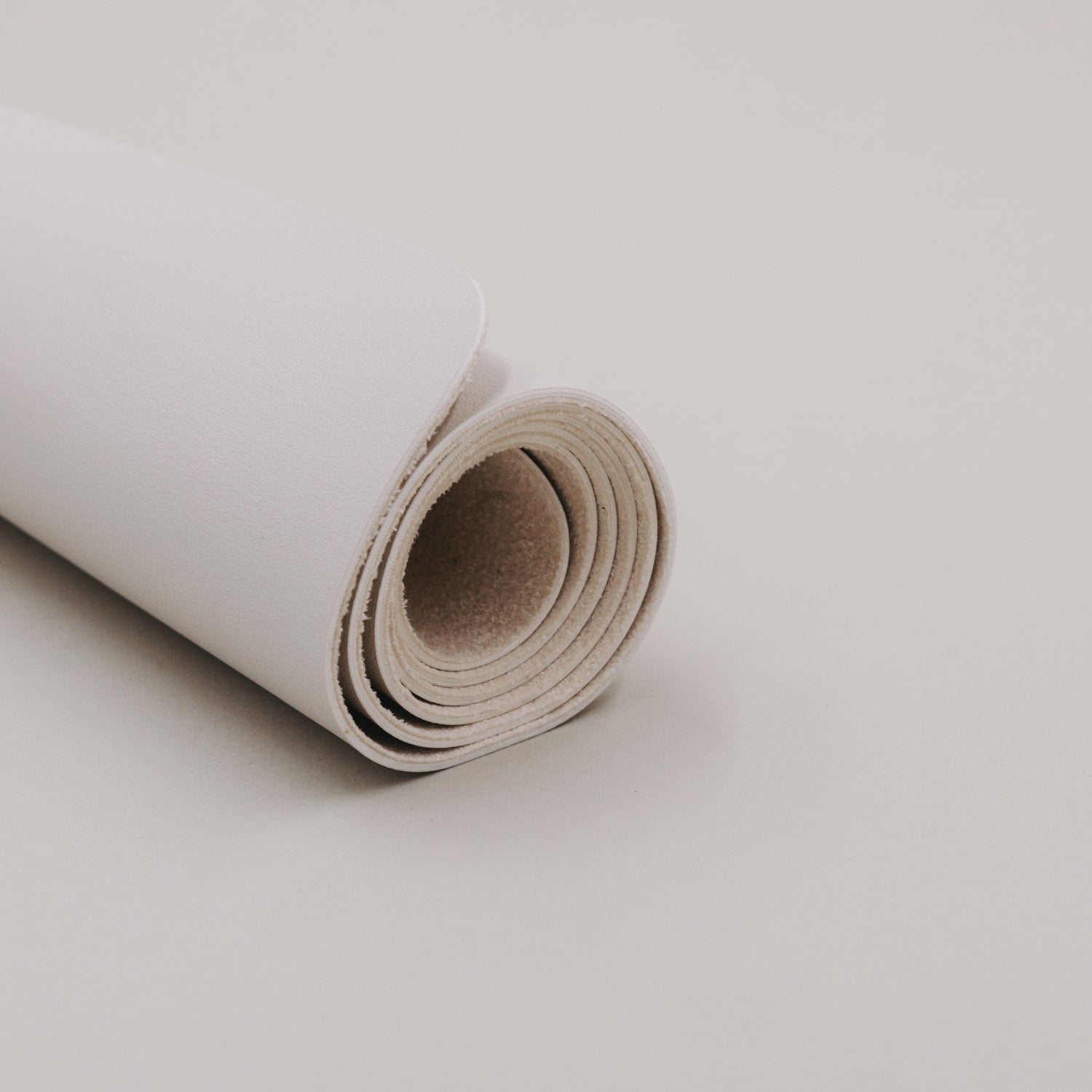 Schreibtischunterlage in Creme, eingerollte Kante mit mehrlagiger Materialstruktur