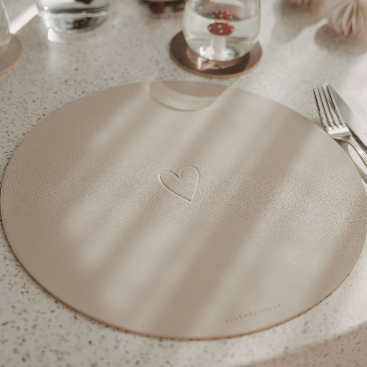 Rundes Platzset (beige) mit eingeprägtem Herzmotiv, 35 cm.