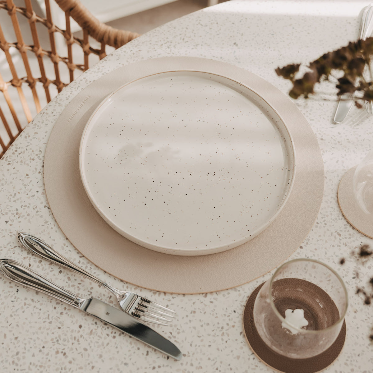 Platzset (beige) mit Herzprägung, rund, mit Teller serviert.