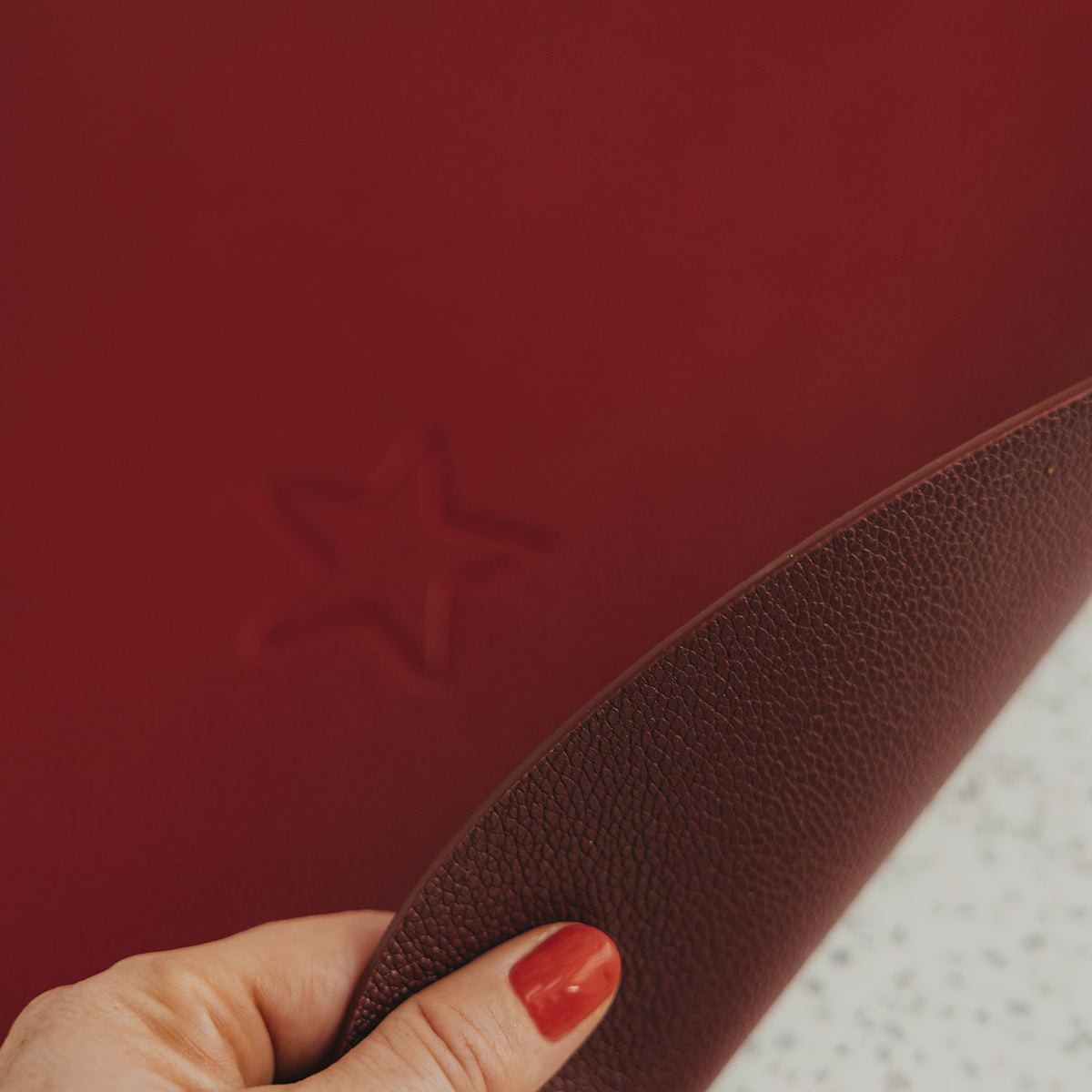 Wendbares Platzset mit Sternprägung, roter Lederoptik, Detail mit geformtem Rand