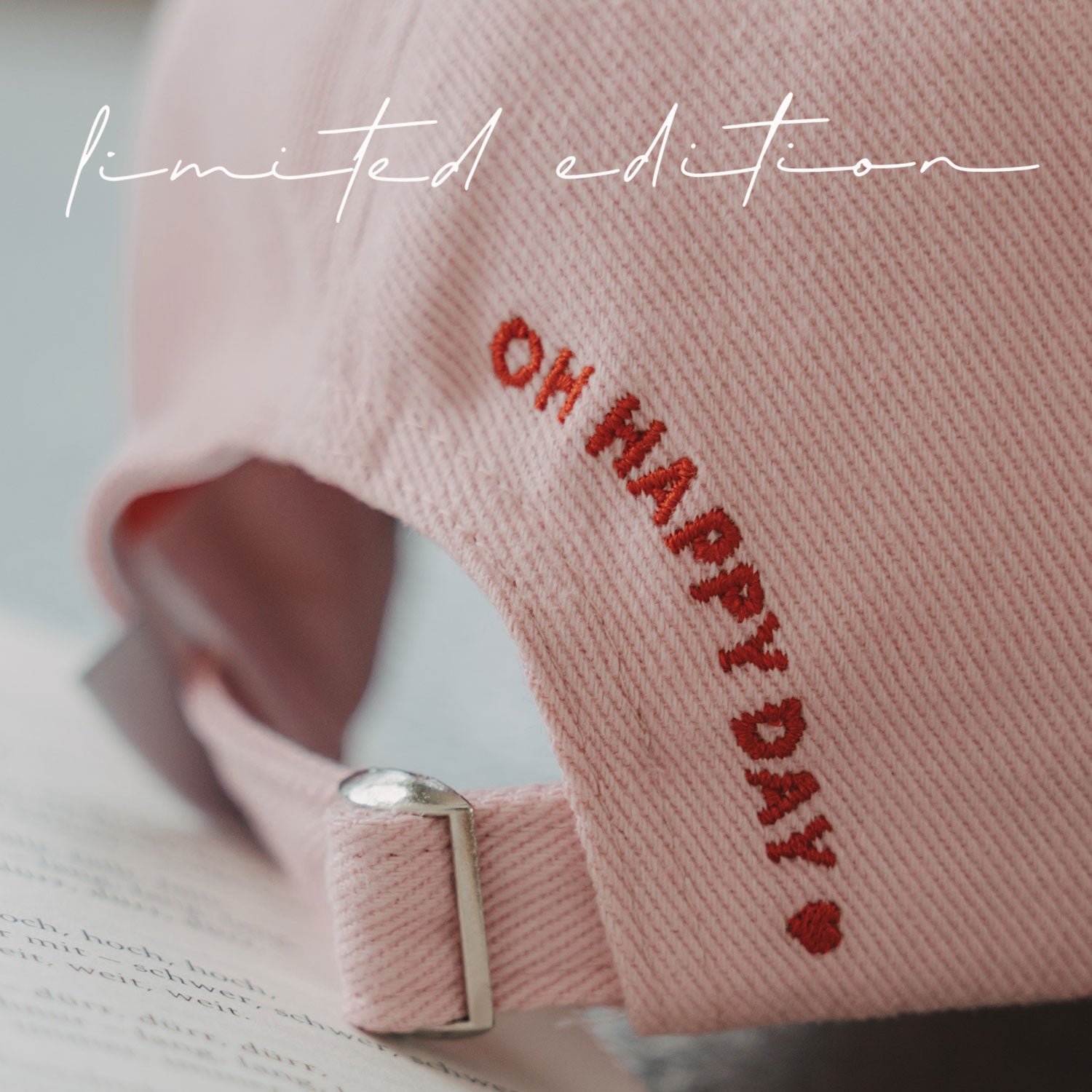Rosa Basecap mit Stickschrift „Oh happy day“ und rotem Herz.