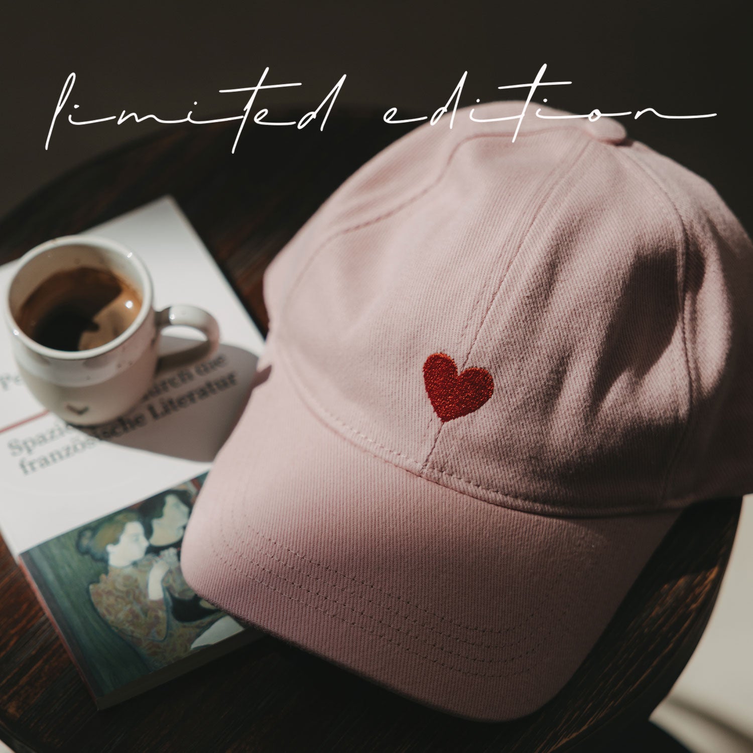 Rosa Basecap mit rotem Herz-Stickmuster vorne.