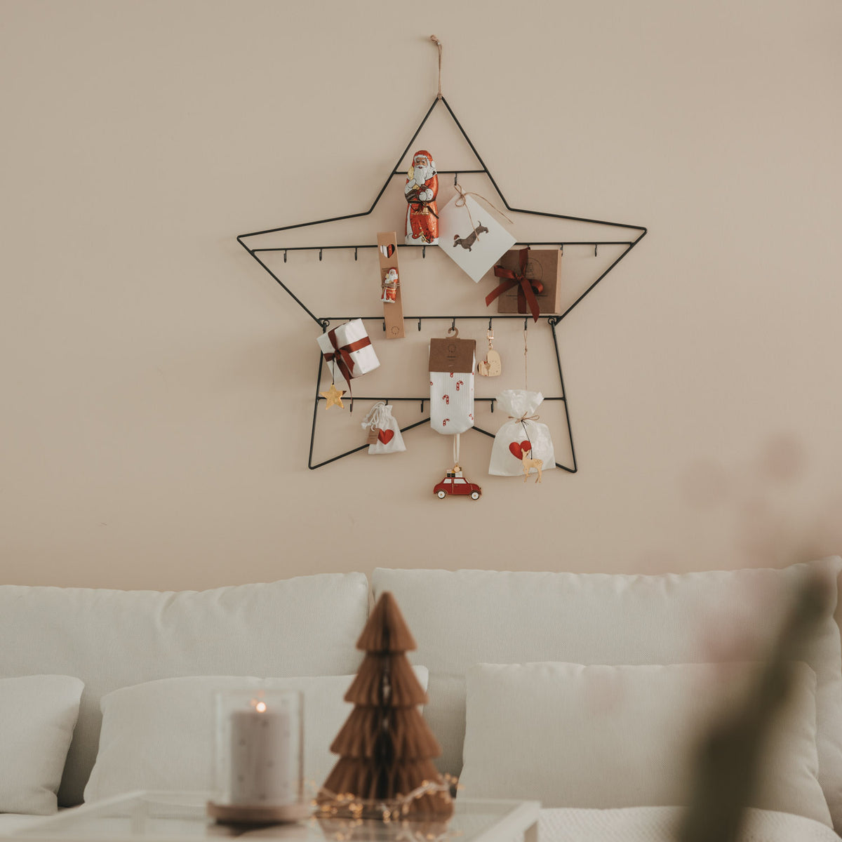 Großer Adventskalender Stern mit hängenden Geschenkboxen und Anhängern am Metallrahmen