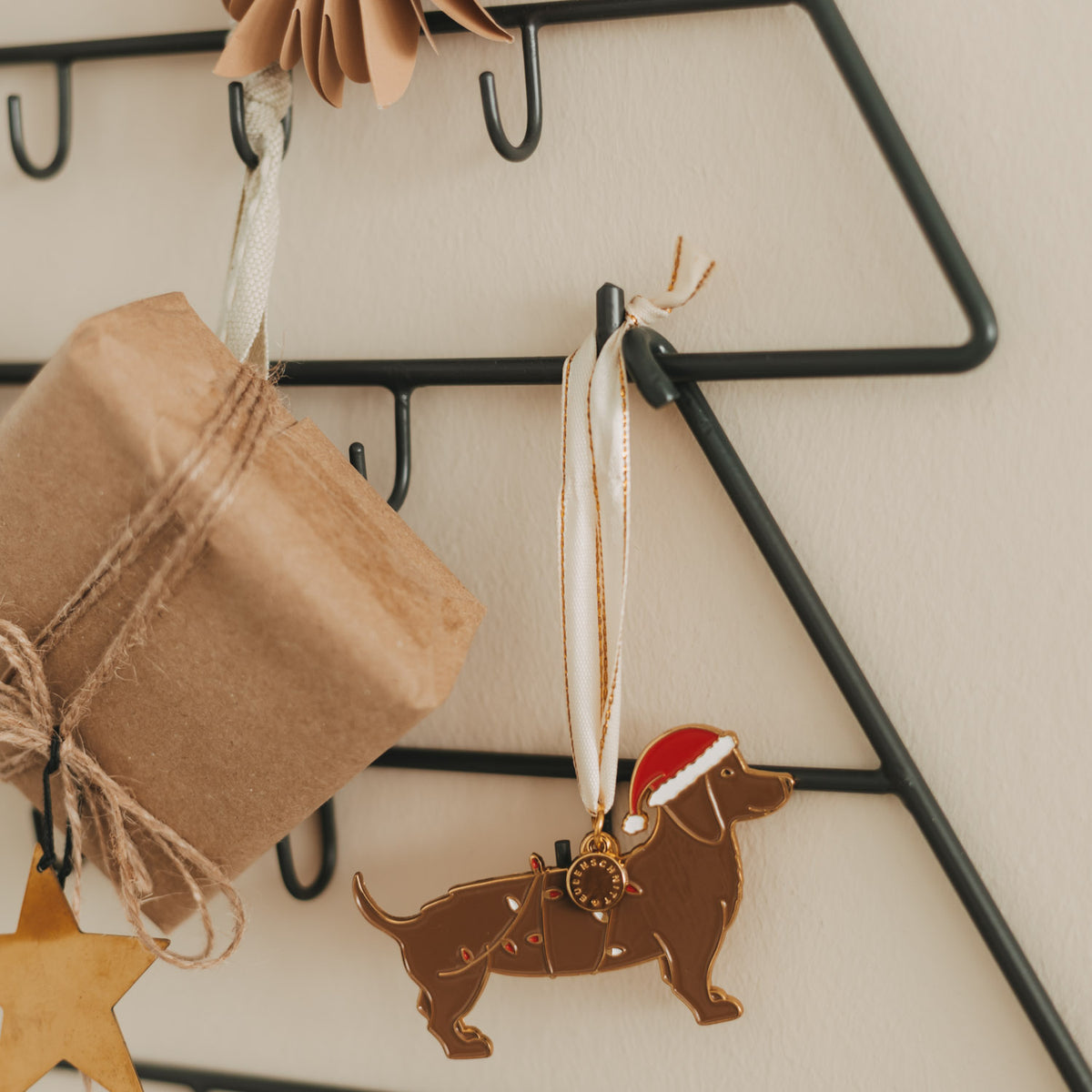 Anhänger: Hund-Silhouette aus Holz, darunter Sterne und Geschenkpapierbeutel
