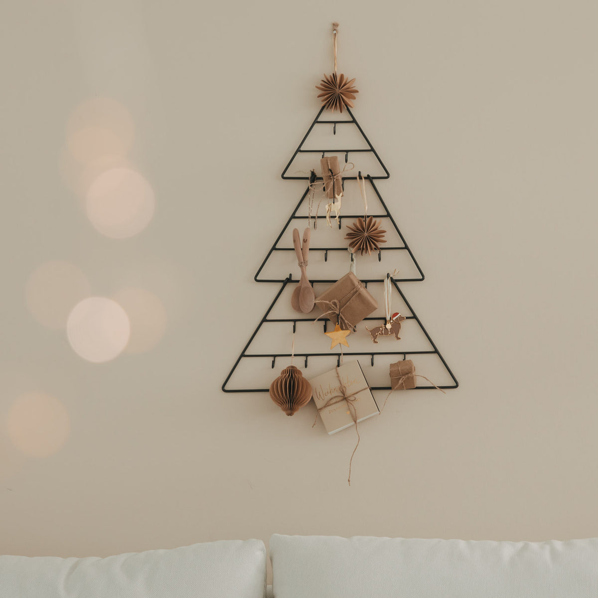 Tannenförmiger Adventskalender mit kleinen Geschenktüten und Holzornamenten