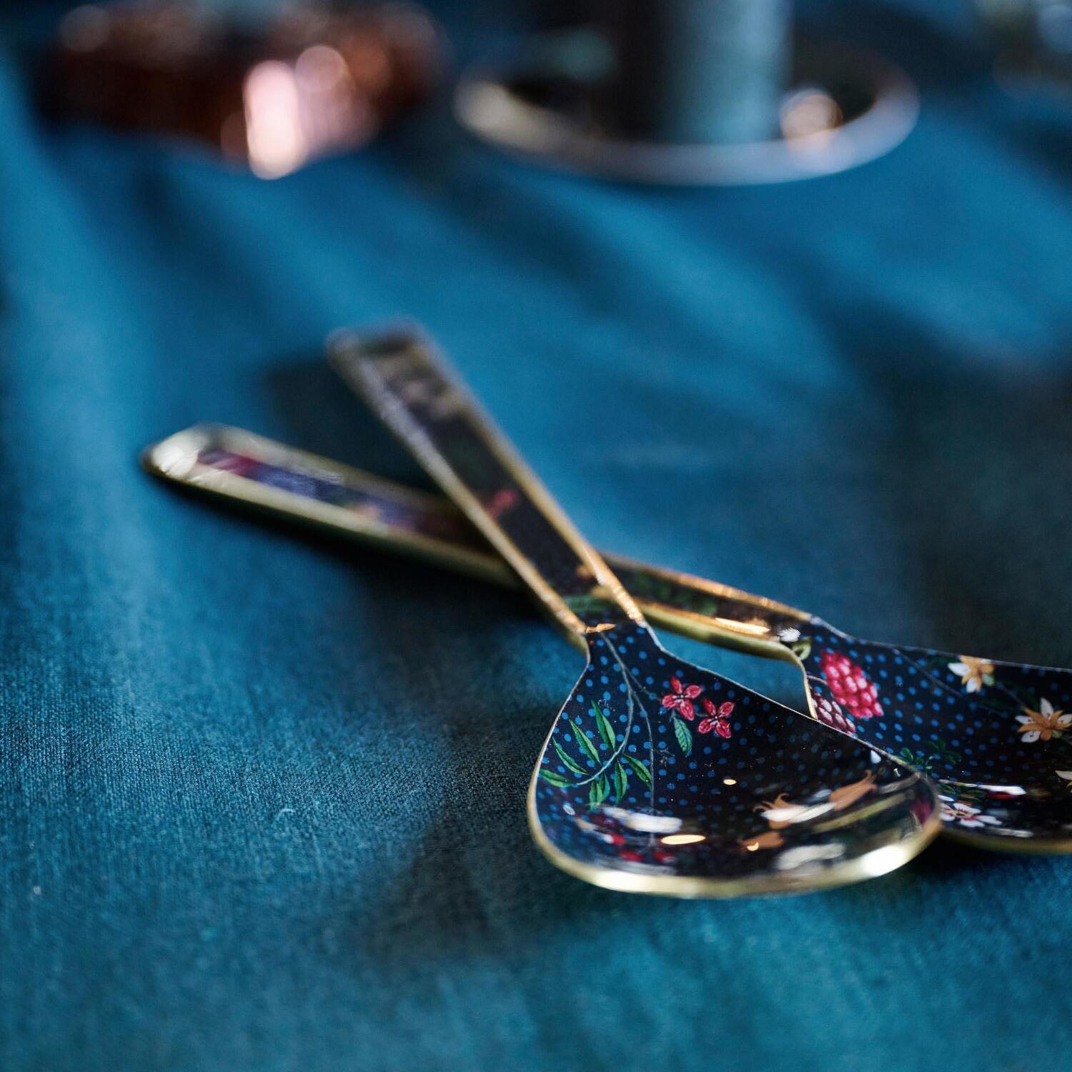 Salatbesteck: zwei Servierlöffel mit floralen Motiven und goldfarbenen Griffen