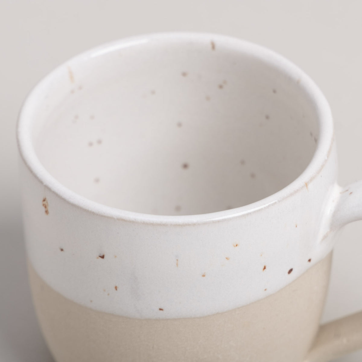 Espressotasse von oben: weißer Rand mit Sprenkeln, beiger Bereich darunter