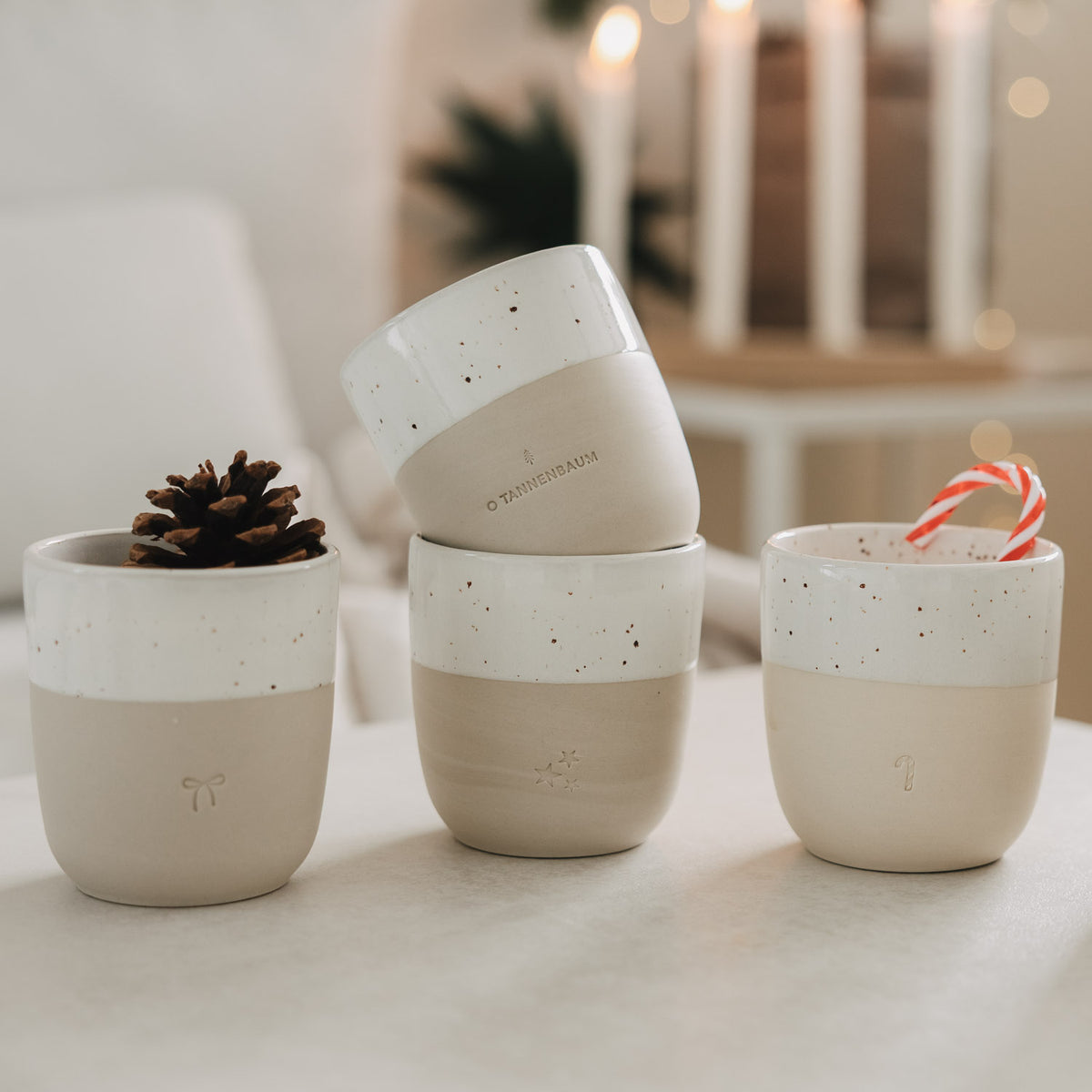 Becher in Naturton mit weißem Rand, Sprenkeln, Schleifen-Emblem und gestreiftem Strohhalm