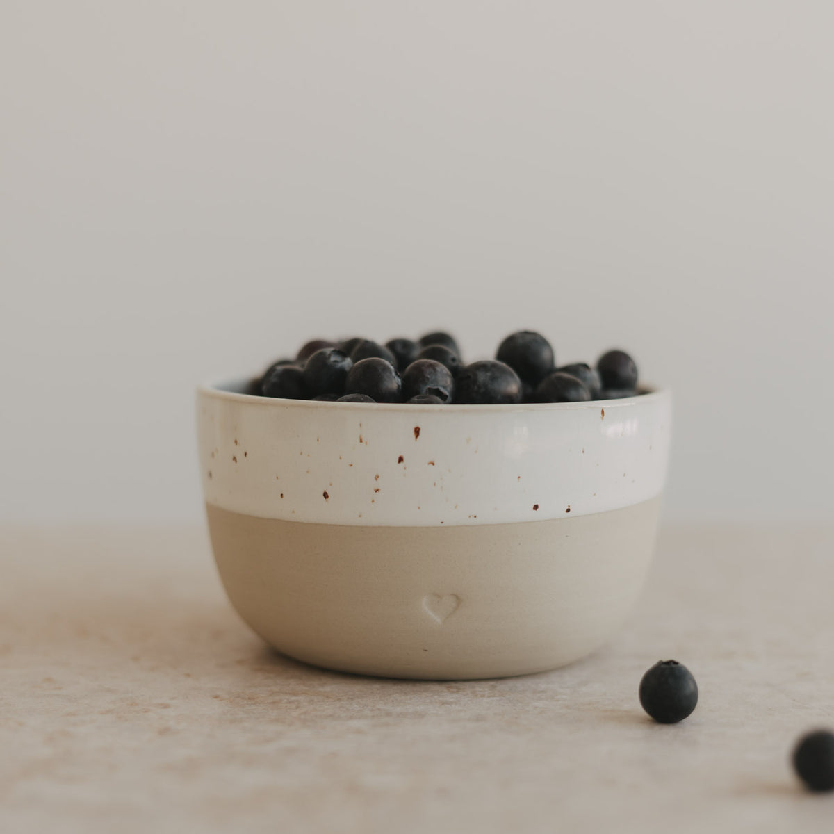 Herz-Schüssel mit Sprenkeln, weiß/cremefarben, gefüllt mit schwarzen Beeren