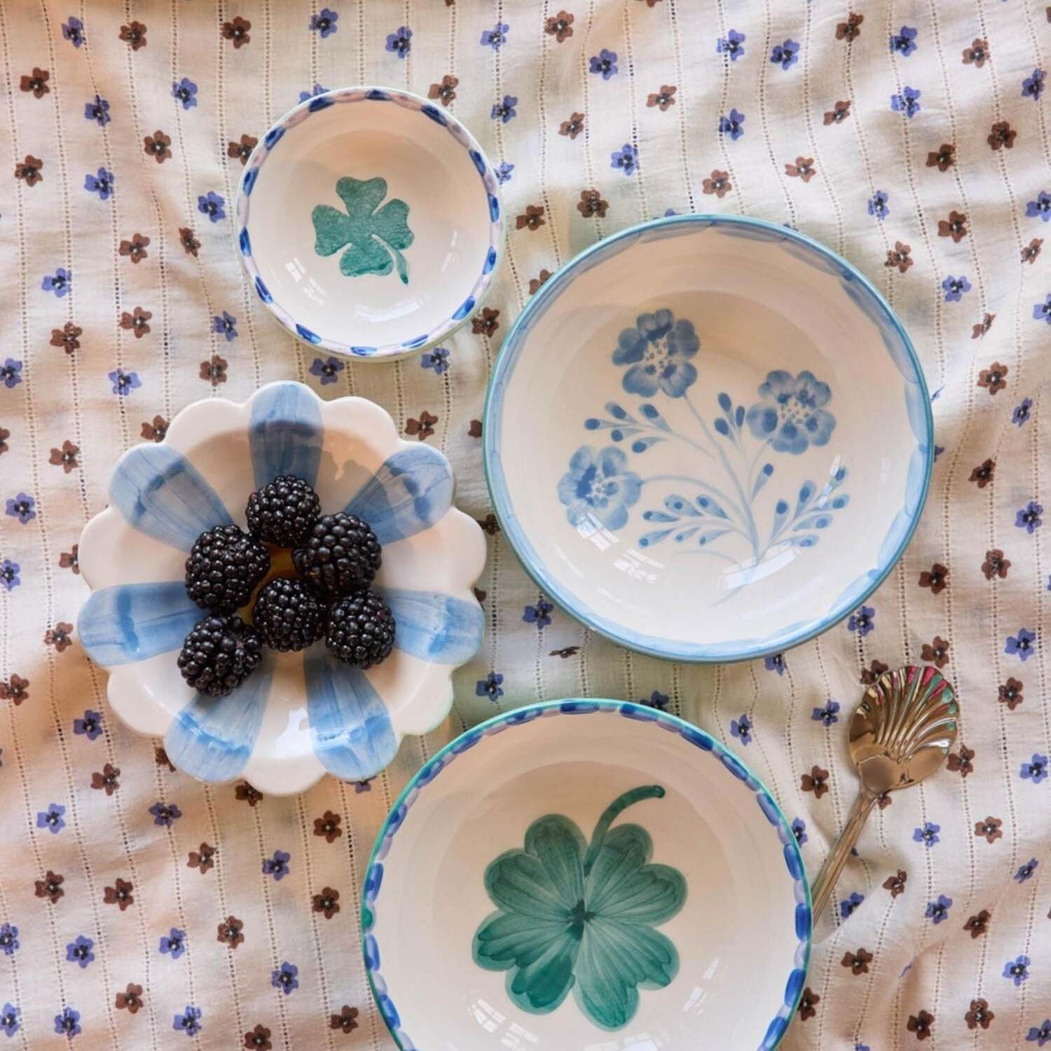 Keramikschale „Cover“: mehrere weiße Schalen mit blauen Rändern und Blumenmotiven